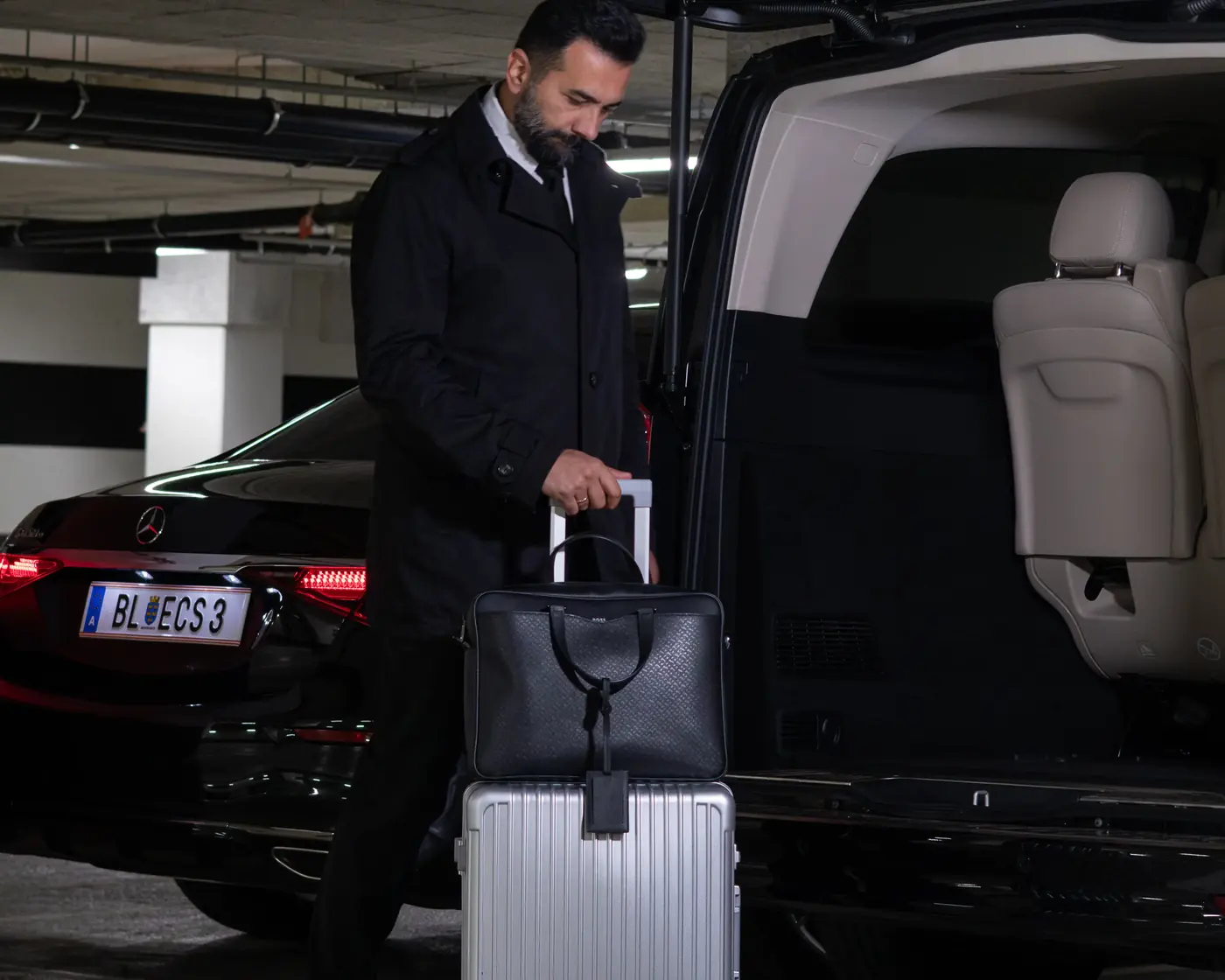 Chauffeur lädt Gepäck in eine Mercedes V-Klasse